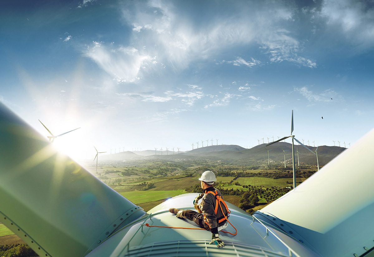 Happy engineer feel success after good work. He standing a top of windmill and looking beautiful sunset landscape; Shutterstock ID 1257908395; purchase_order: -; job: -; client: -; other: -